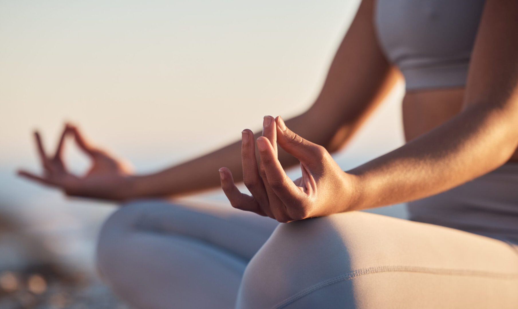 Person meditating outdoors in yoga pose.