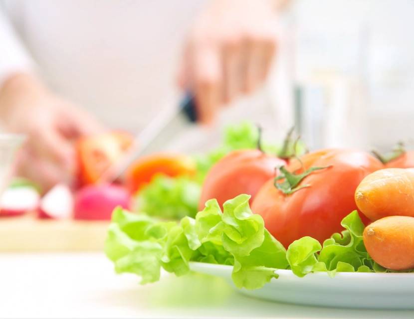 Fresh tomatoes and lettuce on a kitchen counter.