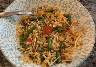 A bowl of vegetable fried rice with green beans and carrots.
